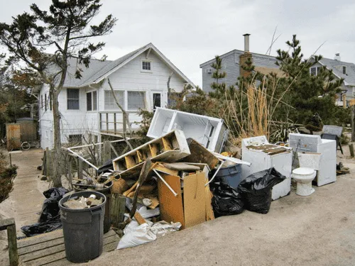 Pile of old furniture and household junk outside a house