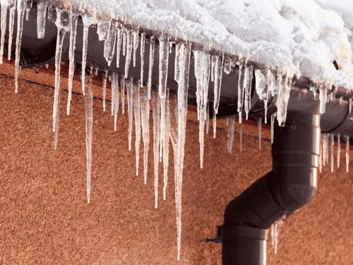 Icicles hanging from a gutter after a winter storm
