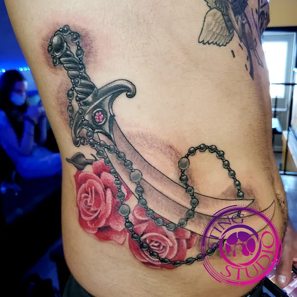 Scimitar roses bead necklace tattoo by Derrick at Sting Studio Ottawa