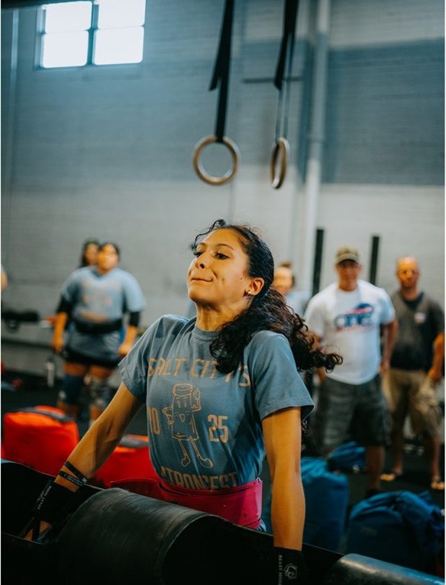 A young athlete pressing the log at a strongman competition