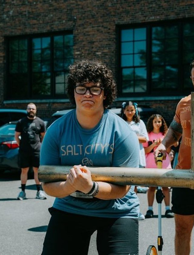 An athlete pressing the axle at a strongman competition