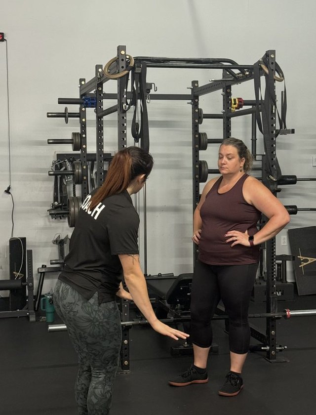 A coach demonstrating the hip hinge
