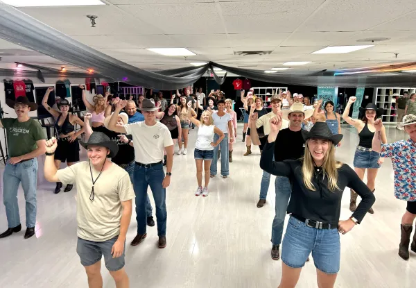 A large group enjoying a line dance together at the studio.