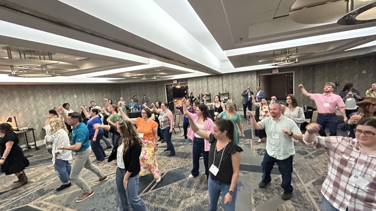 Guests joining a line dance experience in an event ballroom.