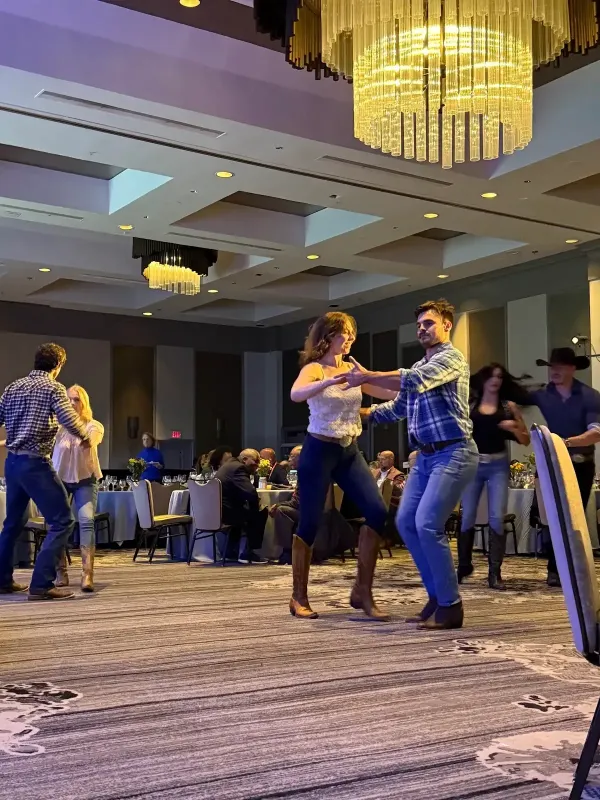 Country dancers performing in Western-style attire at a Loews Hotel event.