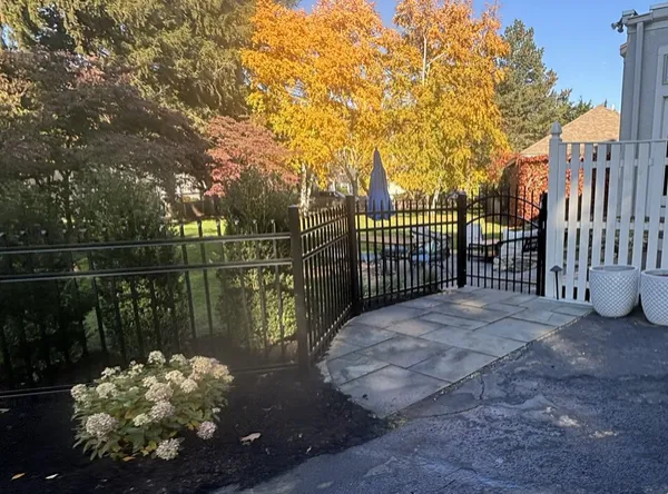 Black aluminum fence and arched walk gate by All Fenced In
