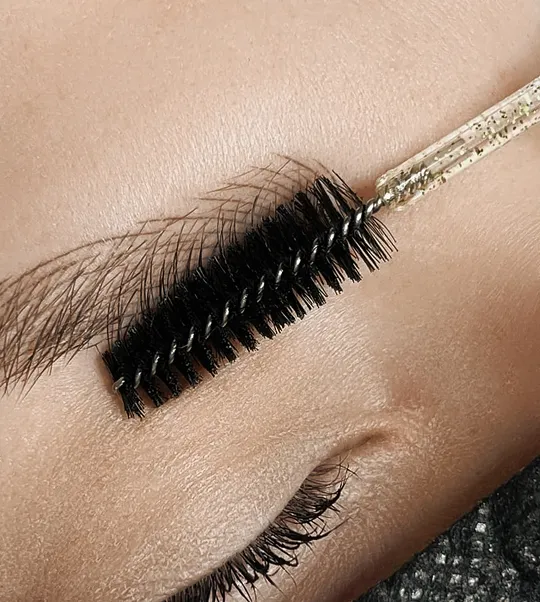 Brows brushed through with a spoolie after a PMU brow treatment