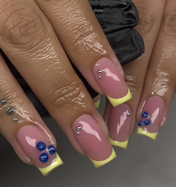 Pink nails with yellow French tips and rhinestones