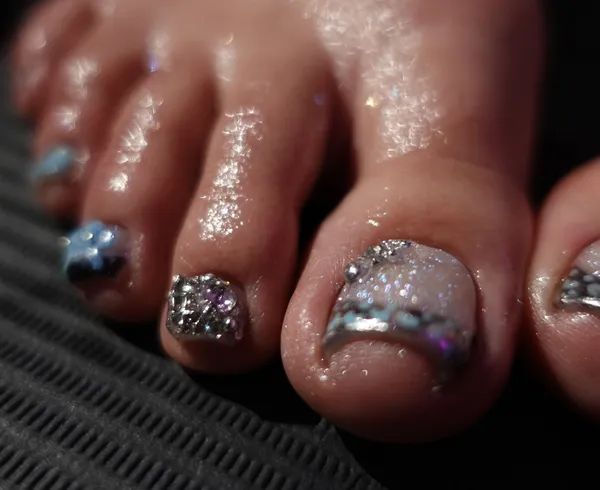 Glossy pedicure with black French tip and gem accent
