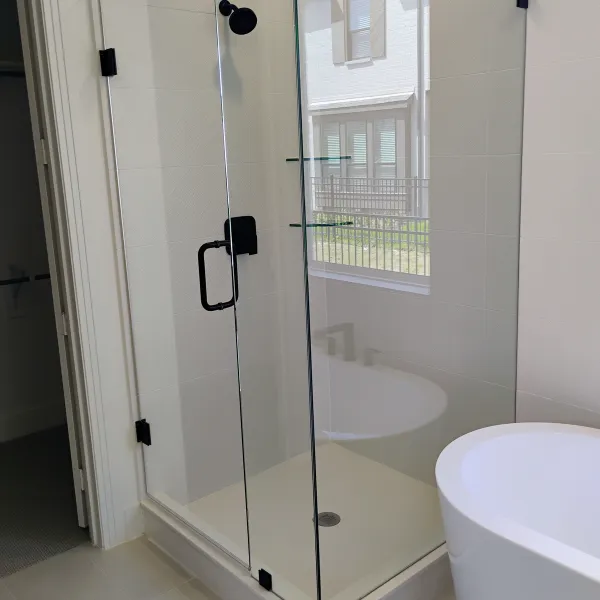 Frameless corner shower beside a freestanding tub