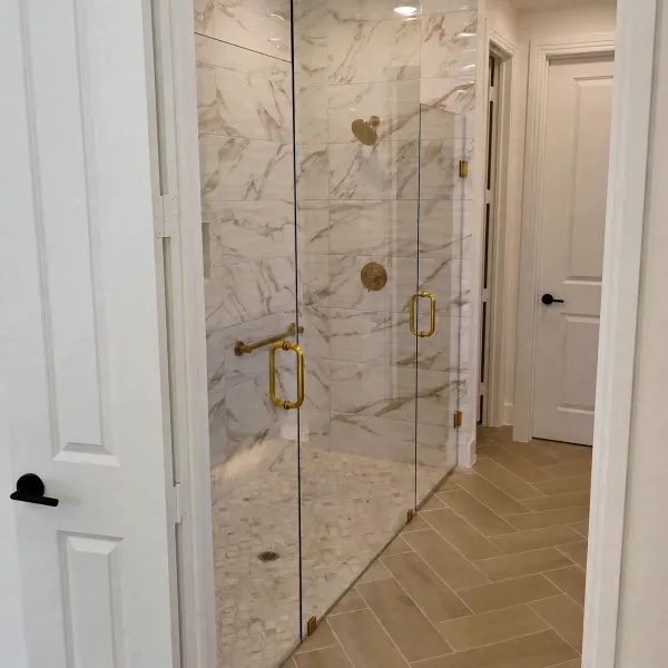 Brass frameless shower doors, herringbone floor