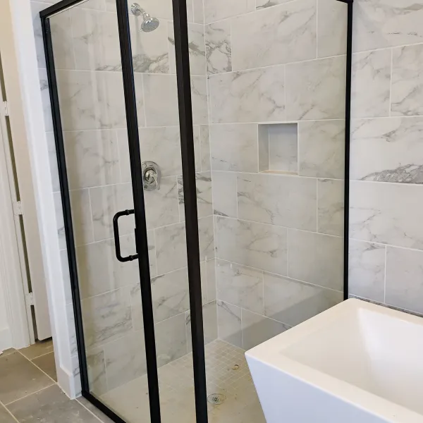 Black-framed shower with marble tile