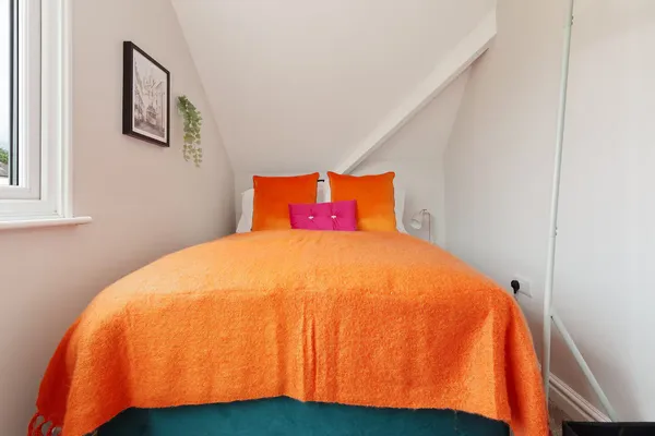 Bedroom with orange bedding at the Worsbrough home