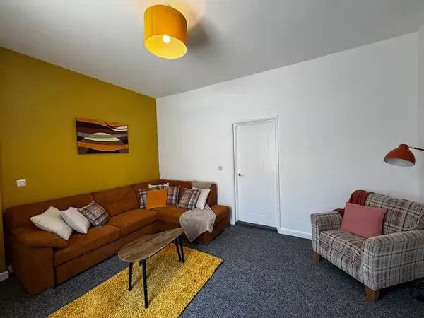 Lounge with tan sofa and yellow accents at the Sheffield family home