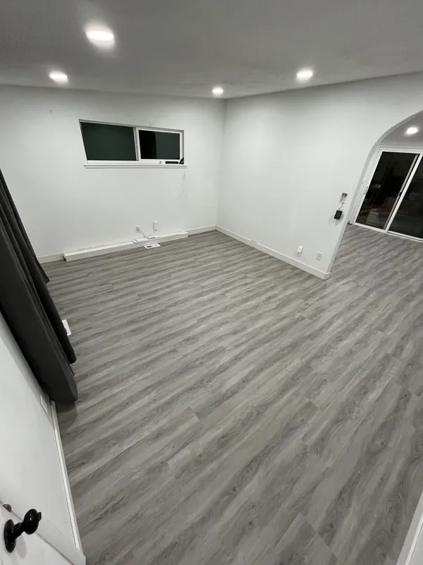 Finished gray plank floor running to the baseboards