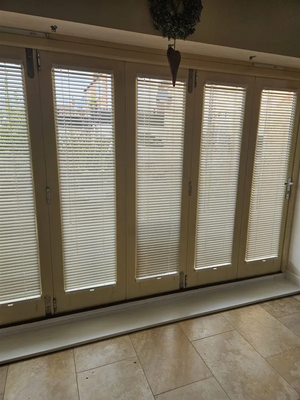 Cream real wood venetian blinds on closed bi-fold doors, fitted by Eclipse SBC in Woodhall Spa
