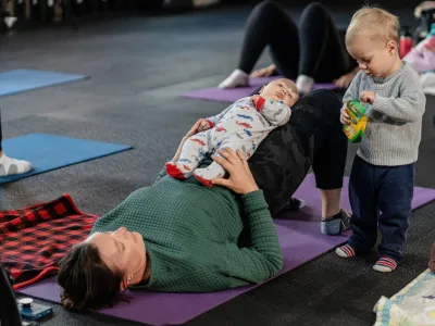 A toddler beside a mom during class