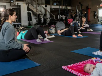 Moms on mats during a postpartum rehab class at Between The Bumpers