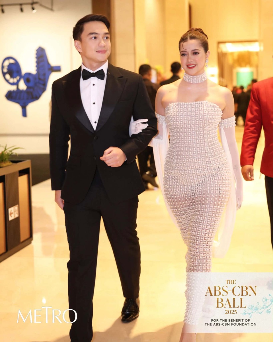 A couple in a pearl column dress and a black tuxedo