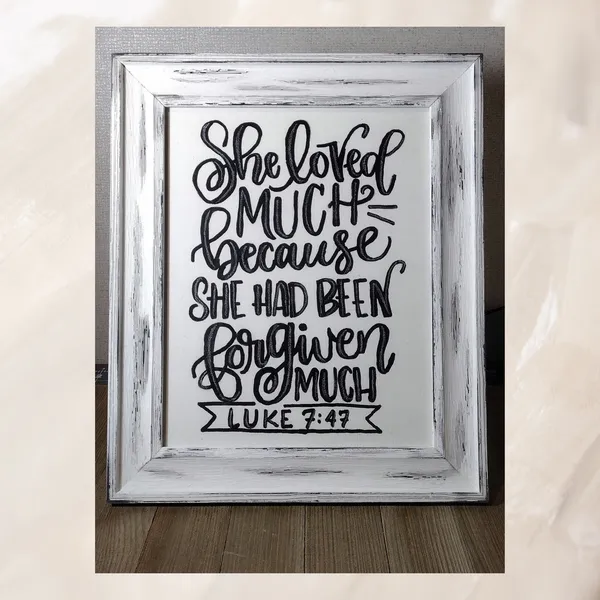 Student's hand lettered sign in a distressed white frame