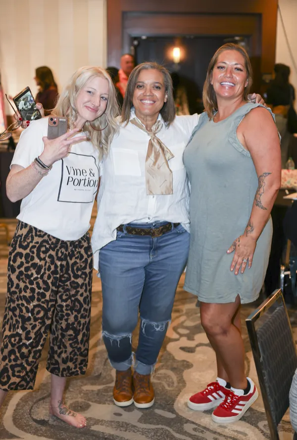 Three women smiling together at a Limitless Ladies gathering