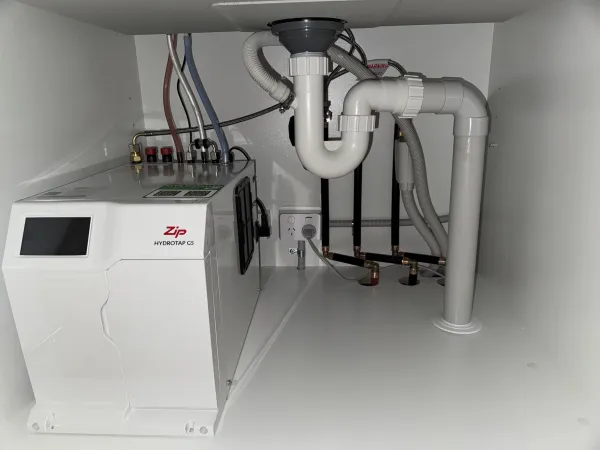 Zip HydroTap unit installed under a sink with pipework