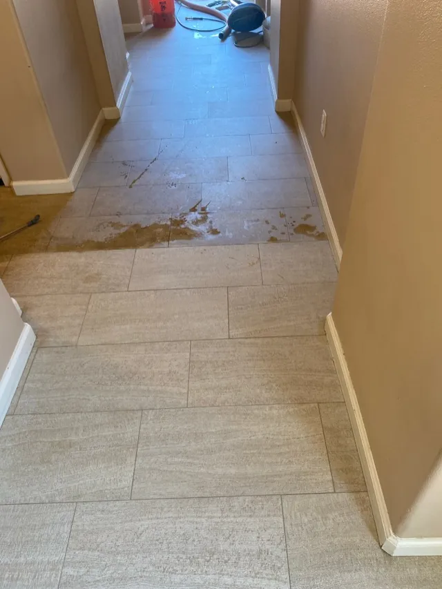 Hallway tile with heavy staining partway through professional cleaning in Silicon Valley CA