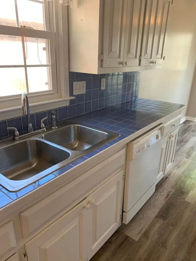Double sink and blue tile kitchen counters detailed by Pretty in Pink Cleaning Service in Wetumpka, AL