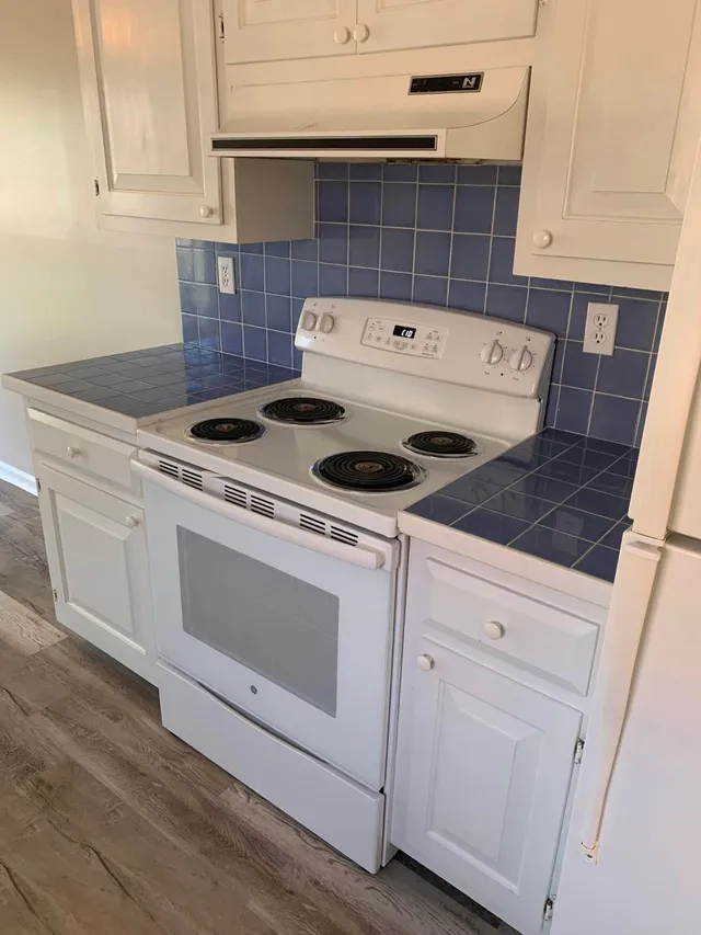 White stove and blue tile backsplash after a kitchen clean by Pretty in Pink Cleaning Service in Wetumpka, AL