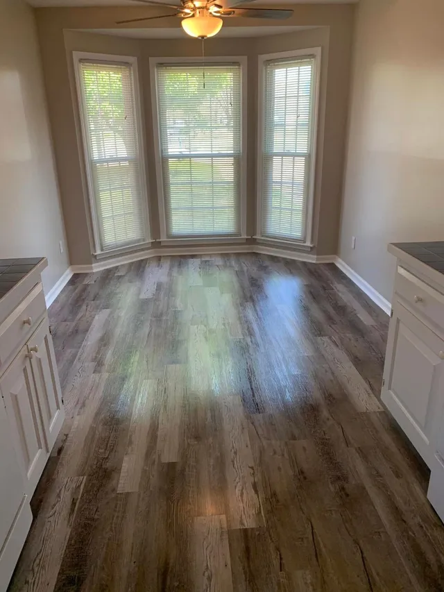 Living room with bay windows and plank floors vacuumed by Pretty in Pink Cleaning Service in Wetumpka, AL