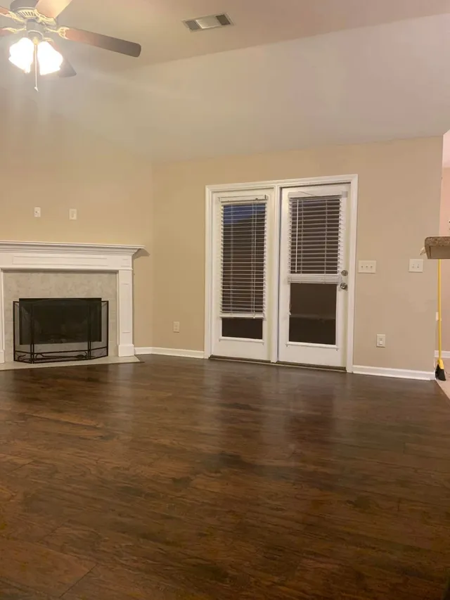 Living room with fireplace and French doors dusted by Pretty in Pink Cleaning Service near Prattville, AL