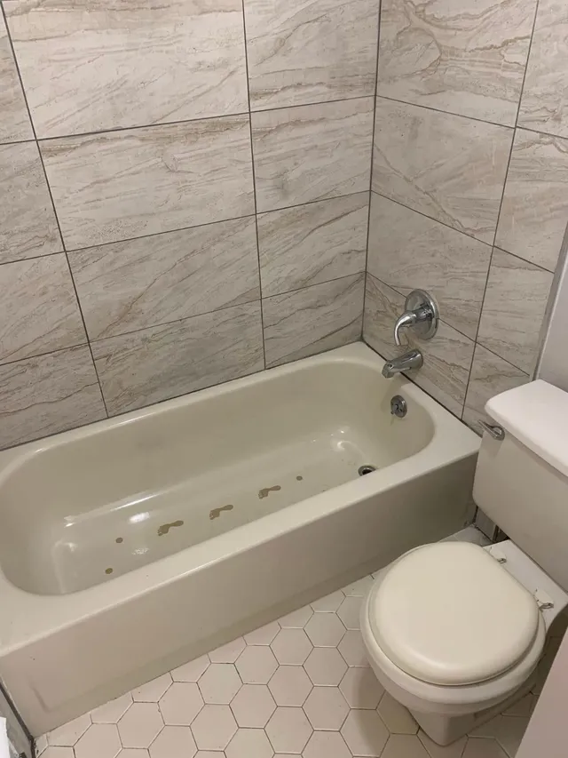 Bathtub with gray tile surround scrubbed by Pretty in Pink Cleaning Service near Montgomery, AL