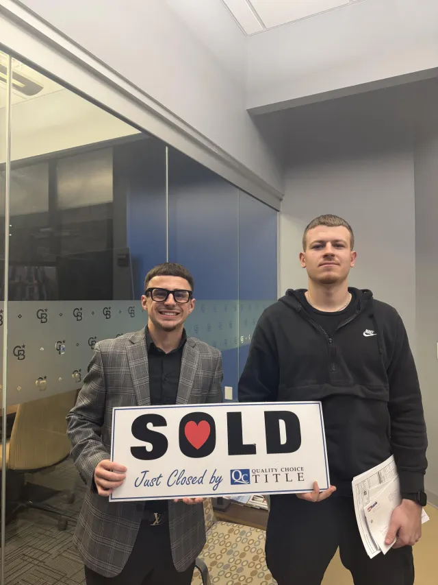 Brenden Gutbrod with a client holding a Sold sign