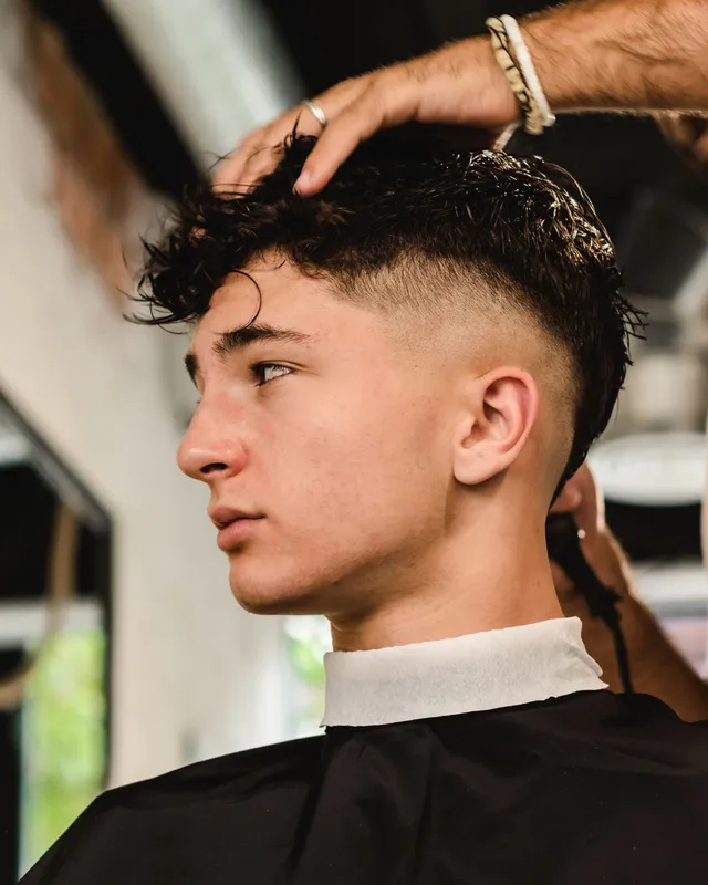Curly top with a high fade at Salon Salman