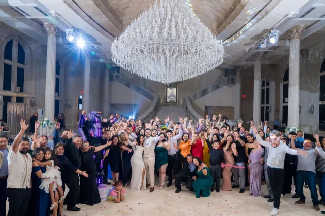 Invitados celebrando bajo un candelabro de cristal