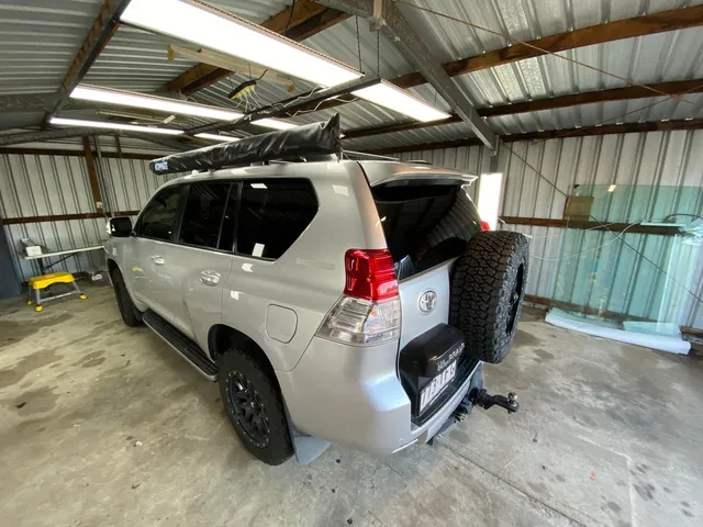 A silver toyota land cruiser is parked in a garage - window tinting by Tint Wright Brisbane