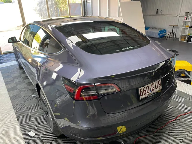 A tesla model 3 is parked in a garage - window tinting by Tint Wright Brisbane
