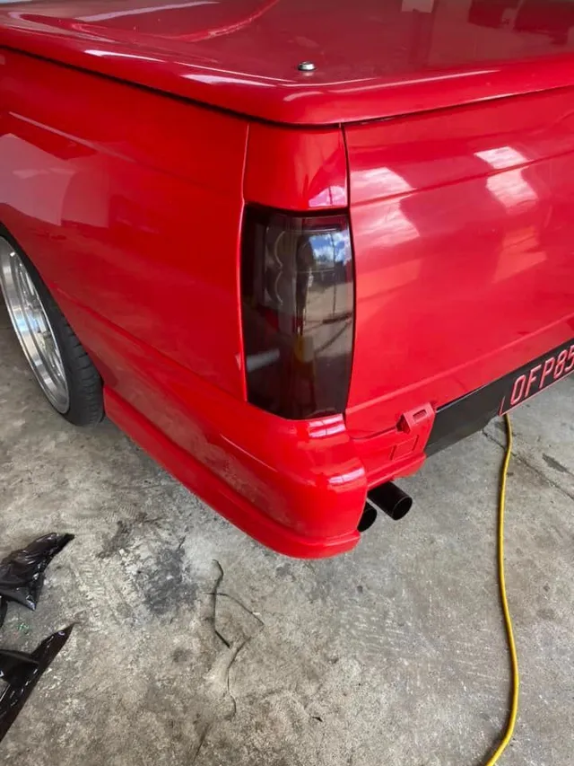 A red truck is parked in a garage - window tinting by Tint Wright Brisbane