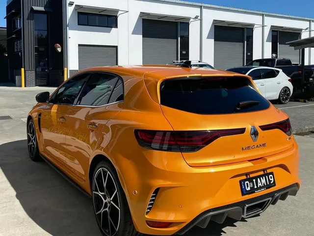 A renault megane rs hatchback is parked in front of a building - window tinting by Tint Wright Brisbane