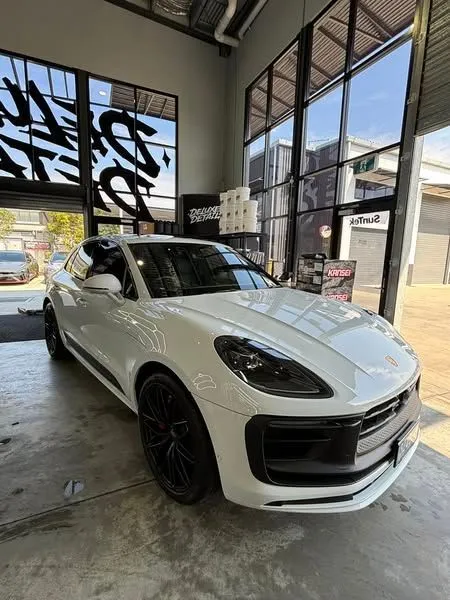 A white porsche macan turbo is parked in a garage - window tinting by Tint Wright Brisbane