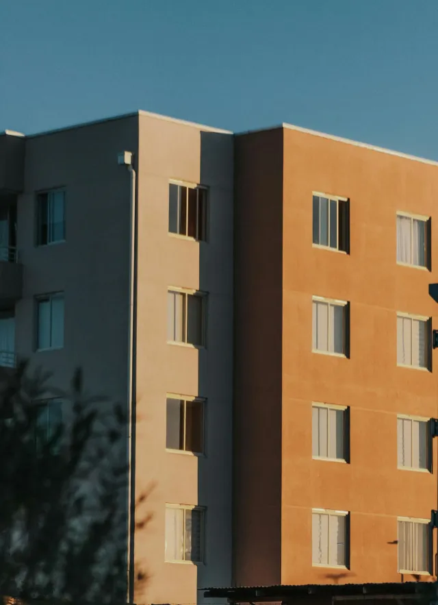 Multi-story building with a flat roofline against a blue sky