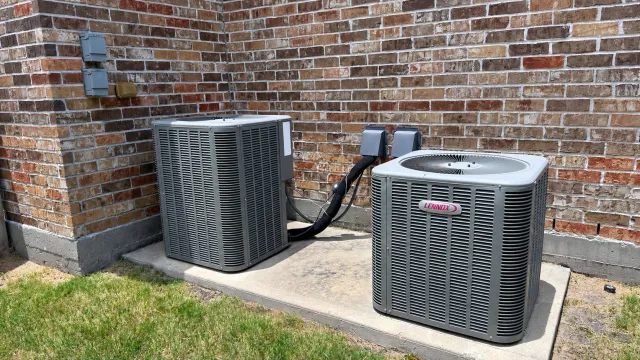 Two Lennox outdoor air-conditioning units at a brick home