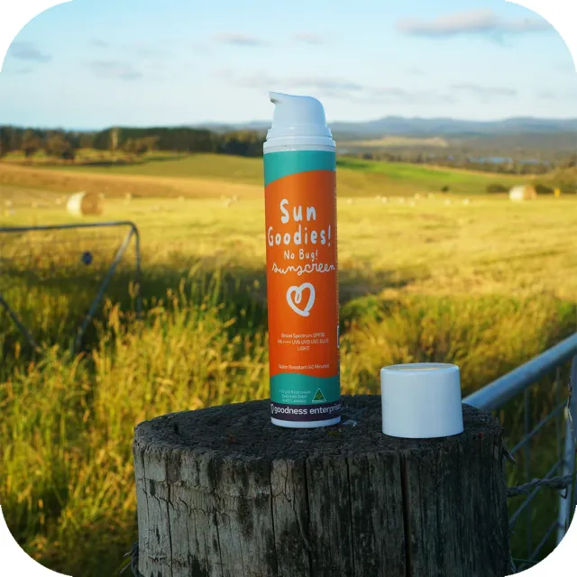 Sun Goodies No Bug SPF 50+ sunscreen bottle on a timber fence post in rural farmland