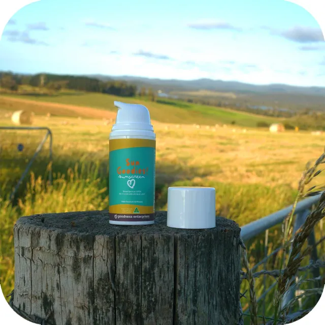 Sun Goodies 36g travel-size sunscreen on a timber fence post in rural farmland