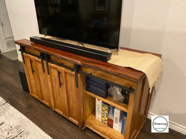 Rustic wood TV media console with sliding barn doors and open shelves, custom built in Houston by Shoup Woodworks