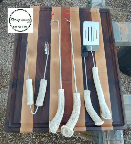 Antler-handled grilling tools laid on a wood cutting board, handcrafted in Houston by Shoup Woodworks