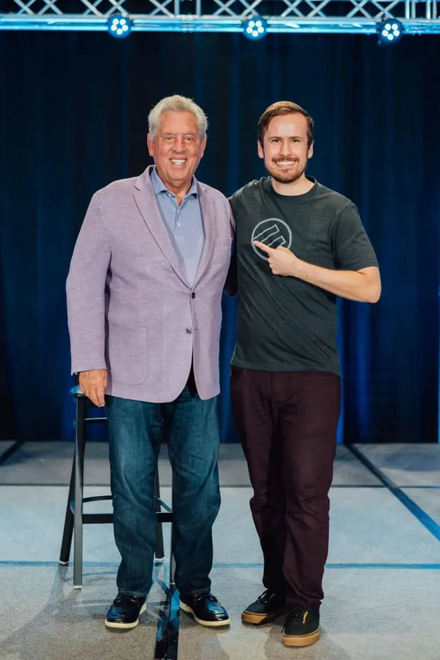 Nick Filipoff on stage with a speaker