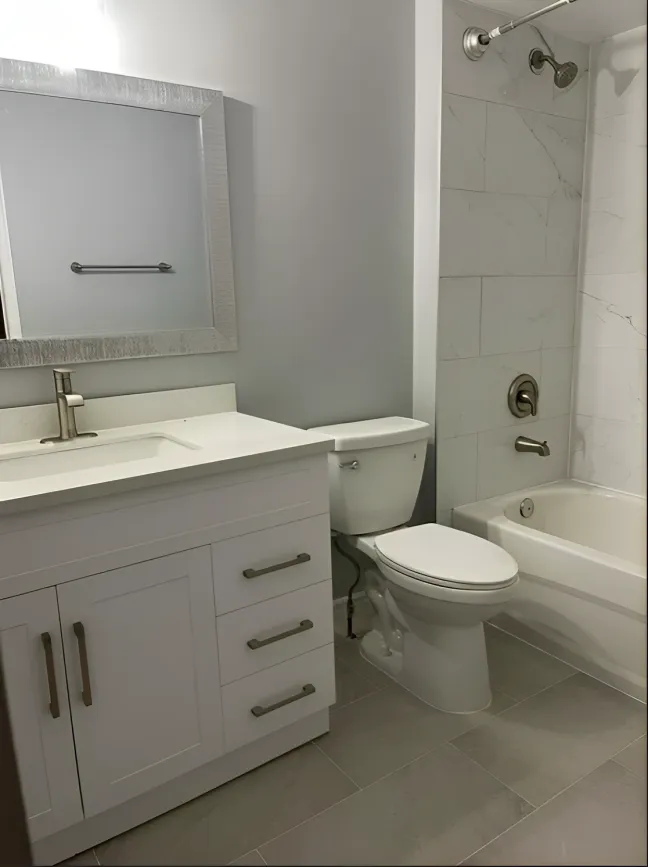 Bathroom with white vanity, wall mirror and tub with marble-look surround