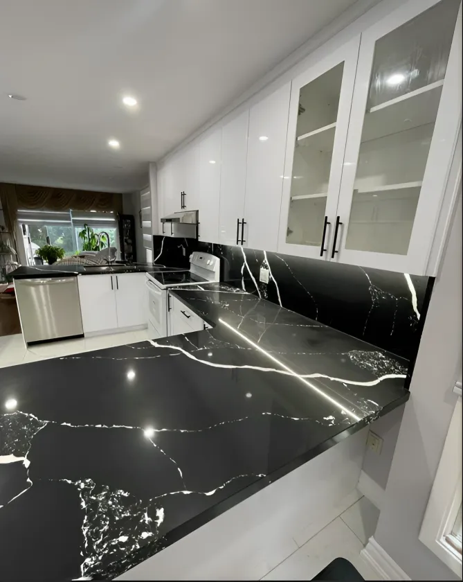 Kitchen with black veined quartz countertops and white upper cabinets