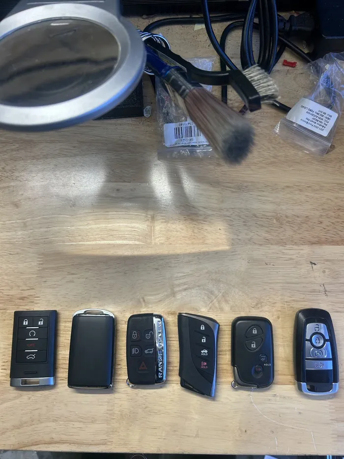 A row of car key fobs and remote keys on a table